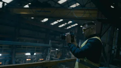 a man in a yellow vest holding a camera